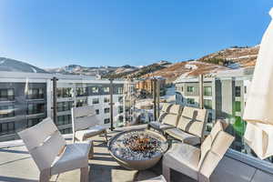 Balcony featuring a mountain view and an outdoor living space with a fire pit