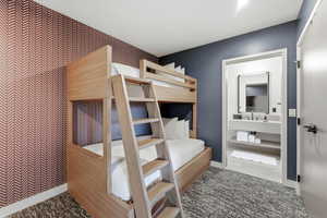 Bedroom featuring wallpapered walls and an accent wall