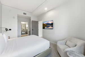 Bedroom featuring ensuite bathroom and carpet