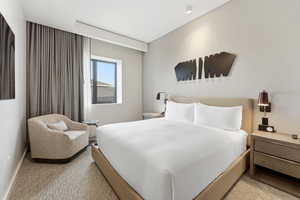 Bedroom with light colored carpet and baseboards