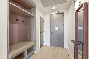 Mudroom featuring light wood-style floors and baseboards
