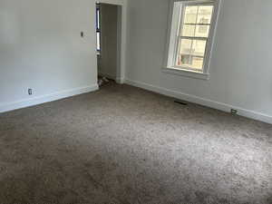 Carpeted empty room featuring baseboards