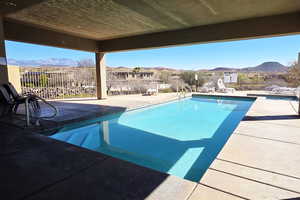 View of pool with patio surround, a mountain view, and a fenced backyard