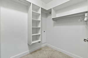 Spacious closet with light colored carpet