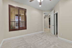 Spare room featuring ceiling fan and light carpet