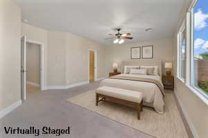Primary bedroom featuring light colored carpet and a ceiling fan. Virtually Staged.