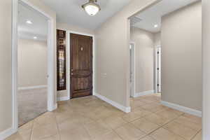 Entrance foyer with recessed lighting and light tile patterned floors