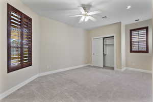 Unfurnished bedroom featuring light colored carpet, a ceiling fan, and a closet
