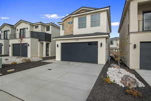 View of front facade featuring stucco siding, stone siding, driveway, an attached garage, and a tile roof