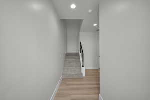 Stairs featuring recessed lighting and wood finished floors