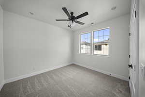 Empty room featuring light colored carpet, ceiling fan, and recessed lighting
