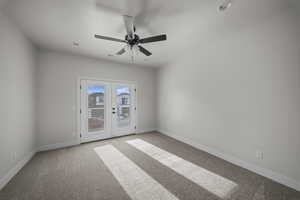 Spare room featuring french doors, light colored carpet, and ceiling fan