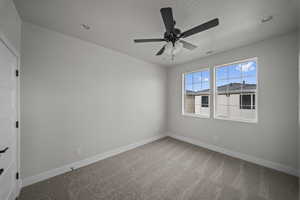 Spare room featuring light carpet and ceiling fan