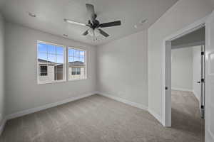 Unfurnished room featuring light carpet and ceiling fan