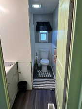 Full bath with vanity and dark wood-type flooring