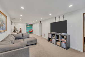 Living room featuring recessed lighting, light colored carpet, and a desk