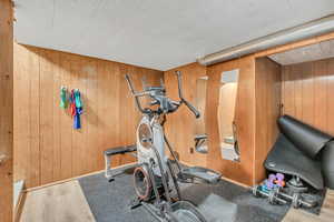 Exercise area with wood finished floors and wooden walls