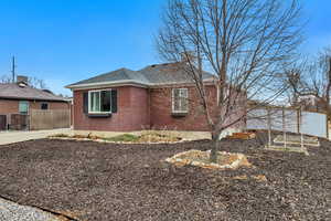 View of side of property with brick siding and roof with shingles