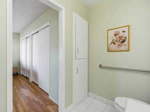 Bathroom with a textured ceiling and light wood-style floors