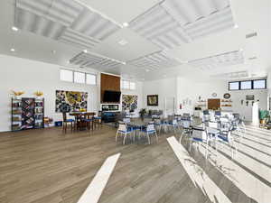 Dining area featuring light wood finished floors, a towering ceiling, and recessed lighting