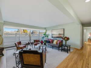 Living room featuring light wood-type flooring and beam ceiling