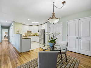 Dining area featuring light wood-style floors, recessed lighting, and a skylight