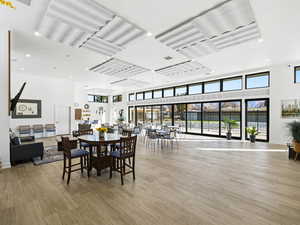 Dining room featuring recessed lighting, a high ceiling, healthy amount of natural light, and light wood finished floors