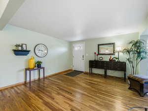 Foyer featuring hardwood / wood-style floors and baseboards