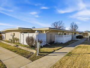 Single story home with a fenced front yard, brick siding, and a gate