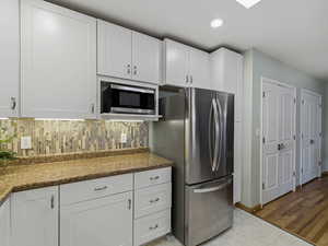 Kitchen featuring stainless steel appliances, white cabinetry, light tile patterned flooring, and recessed lighting