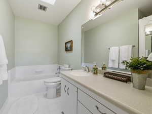 Full bath with a bath, vanity, and light tile patterned flooring