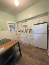 Unit 4 Kitchen with white cabinetry, freestanding refrigerator, light countertops, and dark wood-style floors