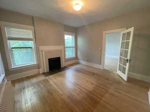Unit 1 Unfurnished living room with a fireplace with flush hearth and light wood-style floors