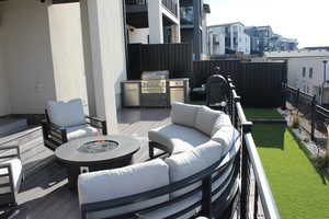 Wooden deck featuring an outdoor living space with a fire pit and a grill