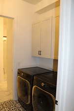 Laundry area with cabinet space and washing machine and clothes dryer