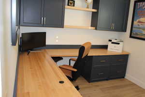 Office featuring built in desk and light wood finished floors