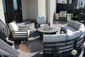 Wooden deck featuring an outdoor living space with a fire pit and grilling area