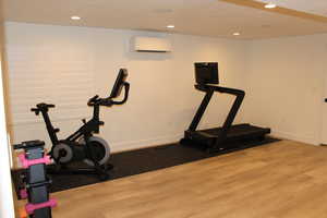 Exercise area with wood finished floors, recessed lighting, and a wall mounted AC