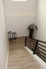 Stairway featuring baseboards and wood finished floors