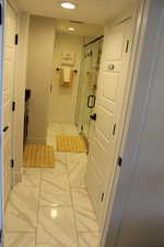 Full bath with light marble finish floors, a shower stall, recessed lighting, and vanity