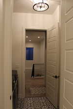 Corridor featuring tile patterned flooring, recessed lighting, and a chandelier