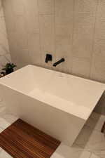 Full bathroom featuring a freestanding tub and marble look tiles