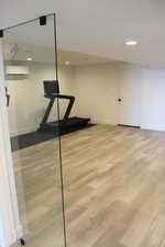 Workout room with light wood-style flooring, recessed lighting, and a wall mounted AC