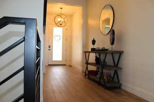 Entryway featuring light wood-style flooring and a chandelier