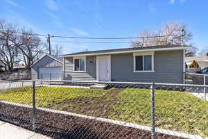 Ranch-style home featuring a fenced front yard and a garage