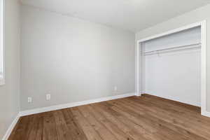 Unfurnished bedroom featuring hardwood / wood-style floors and a closet