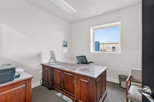 Office space featuring baseboards and dark carpet