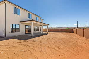 Back of house featuring a fenced backyard, a patio area, and stucco siding