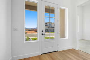 Entryway with baseboards and wood finished floors