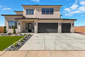 Prairie-style house with stucco siding, stone siding, driveway, and a garage